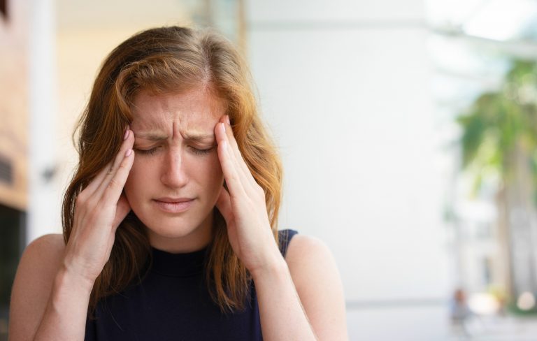 Mulher tendo crise de cefaleia