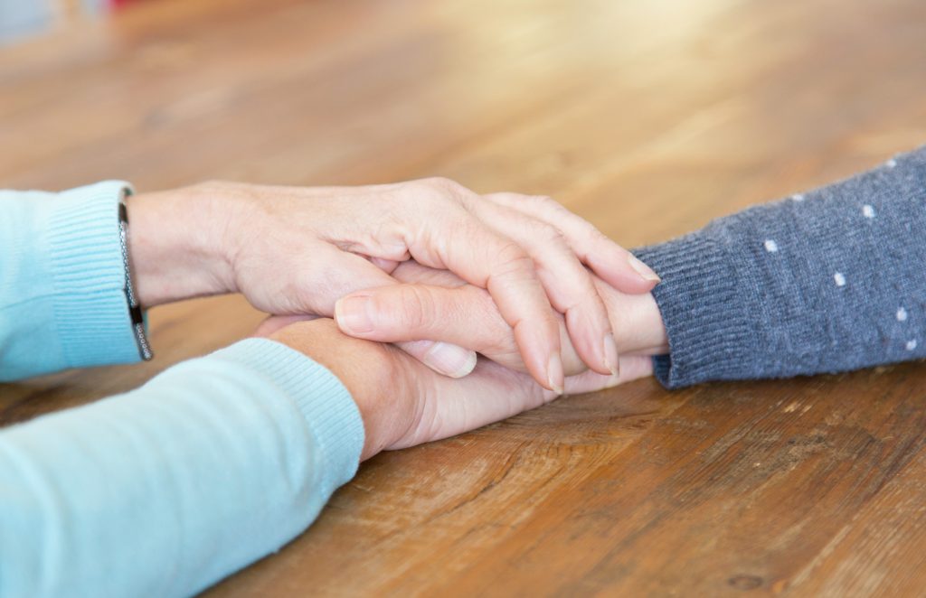 Mãe e filha de mãos dadas lutando contra a depressão